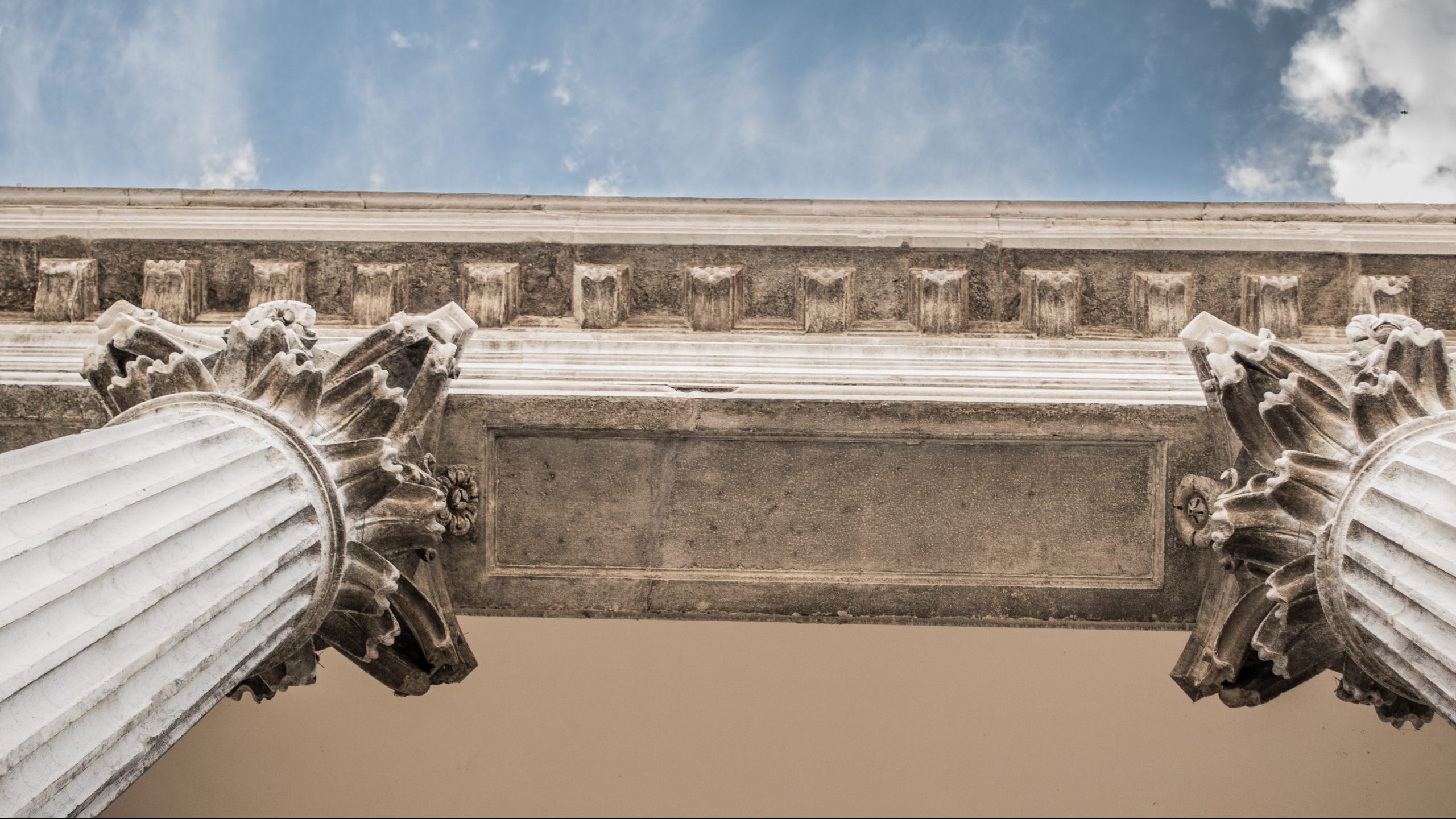 Photography of courthouse columns, from viewpoint looking up toward sky