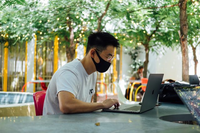 man in mask on computer | elearning