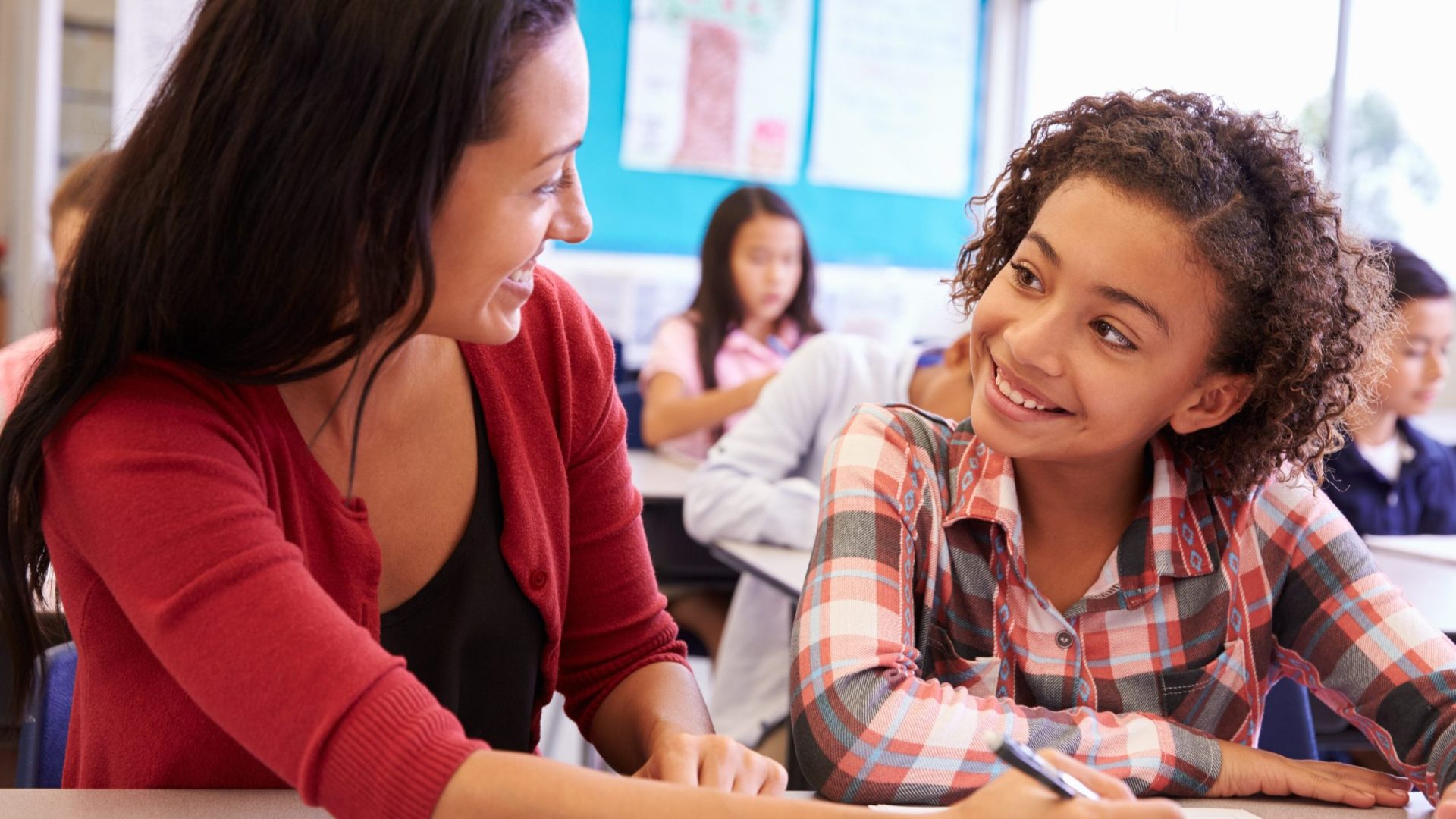 Photograph of teacher and teen smiling at each other