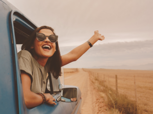 youth-leaning-out-of-a-truck-window-driving-down-a-road-300x225