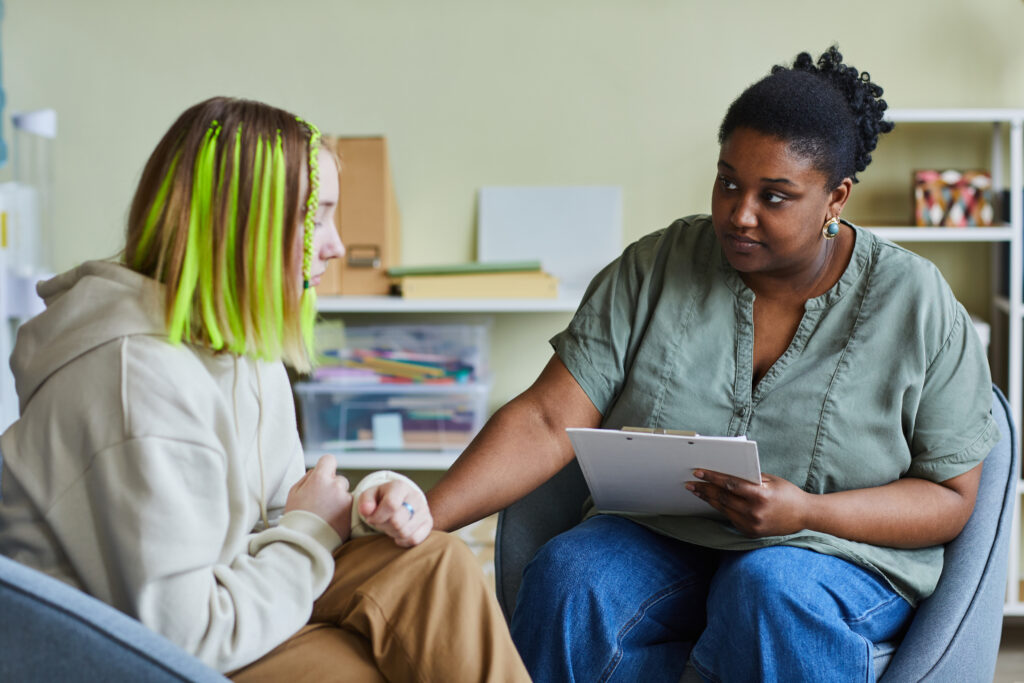 Psychologist working with upset girl at office