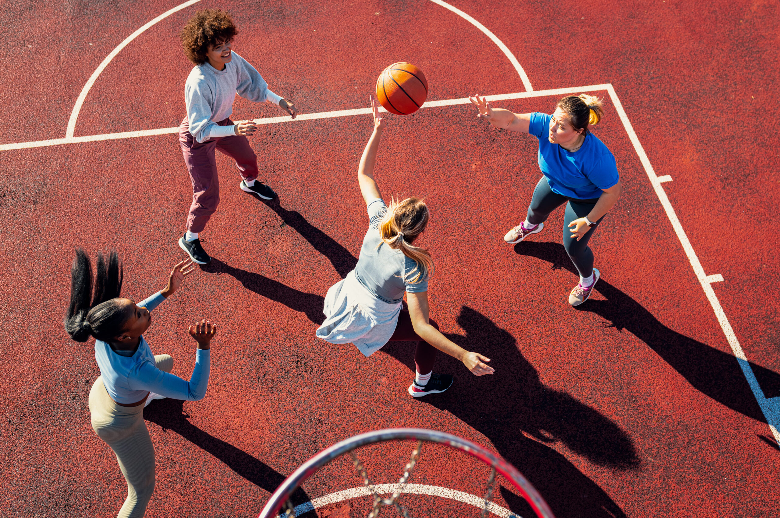 Four young women playing basketball